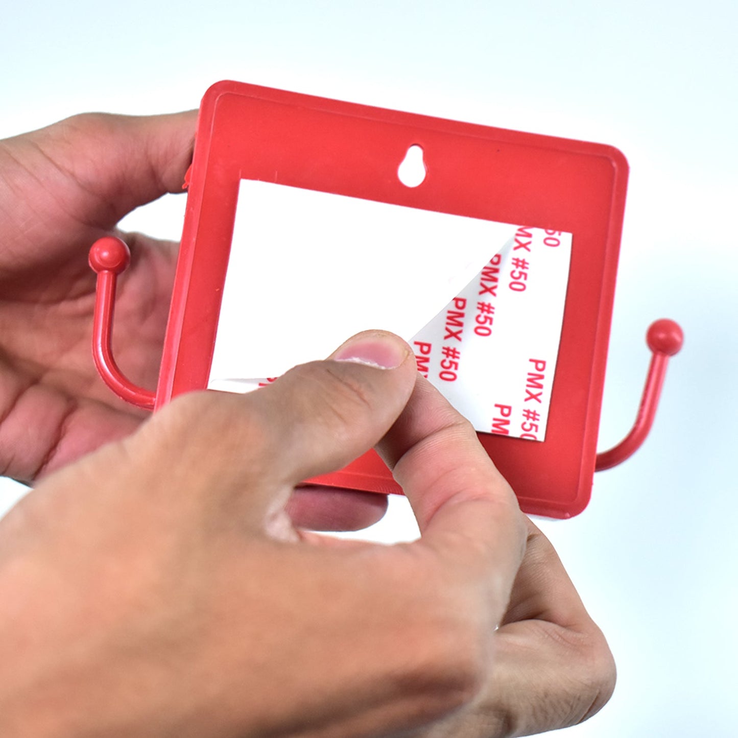 Wukusy 6201a wall-mounted storage box for remote and mobile accessories with two side hooks, mounted on a wall.