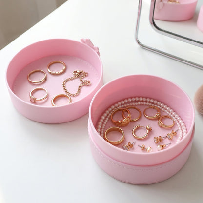 Small round Wukusy jewelry storage box with snap closure, portable organizer case for jewelry and accessories.