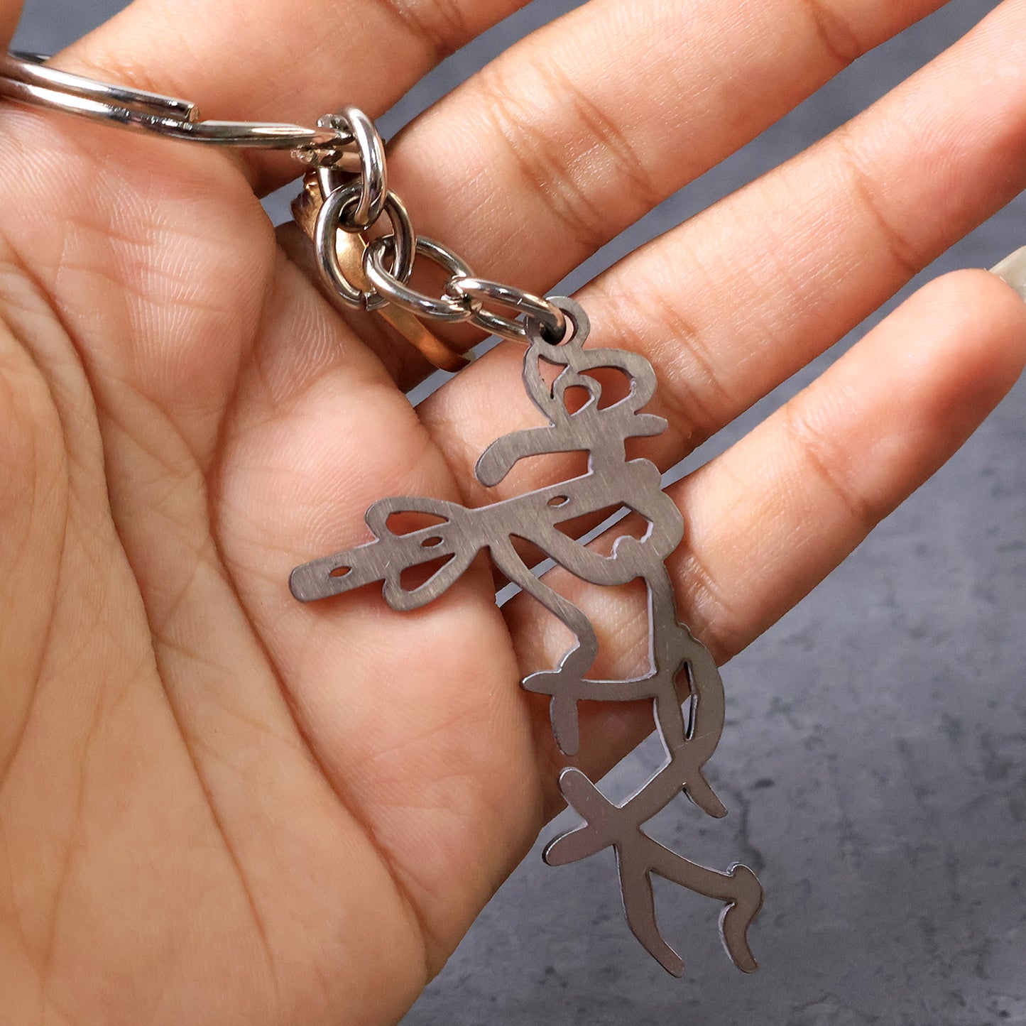 Wukusy Divine Krishna flute metal keychain with intricate design, featuring a detailed Krishna figure and traditional motifs.