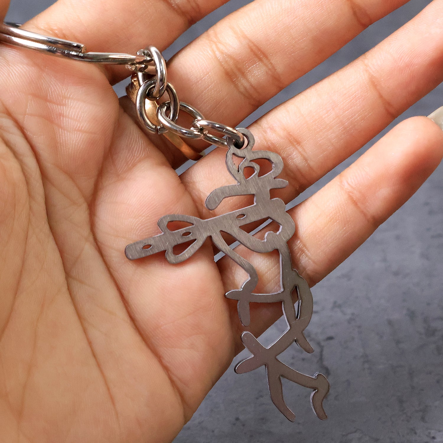 Wukusy Divine Krishna flute metal keychain with intricate design, featuring a detailed Krishna figure and traditional motifs.