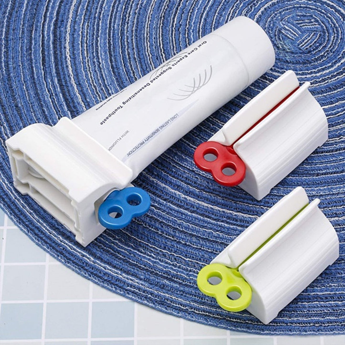 Wukusy 2514 rolling tube toothpaste squeezer and holder stand on a bathroom countertop, showing its compact design and functionality.
